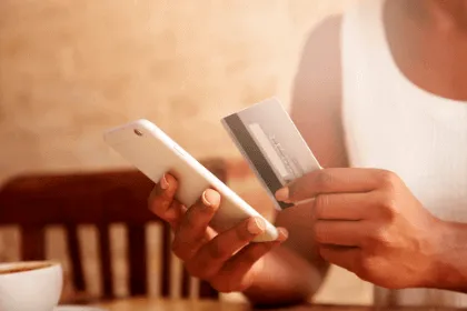 pessoa com celular e cartão na mão